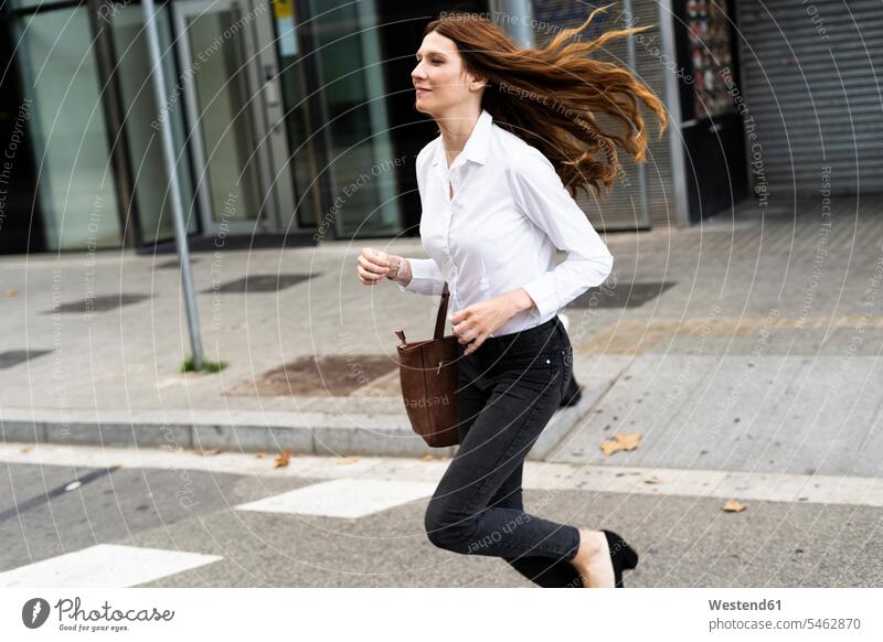Businesswoman running in the street streets City Street City Streets on the move on the way on the go on the road urban urbanity fast quick speediness rapidity