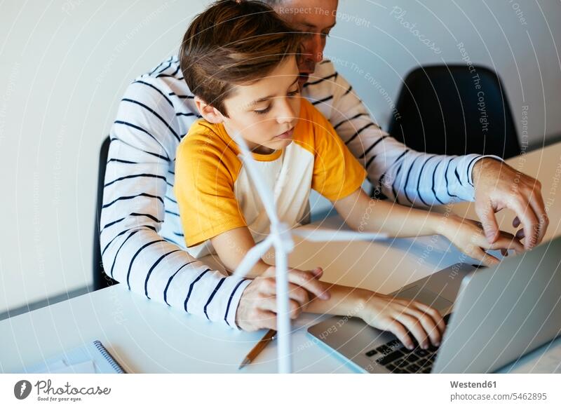 Father and son using laptop next to wind turbine model wind wheel windmills wind turbines wind wheels sons manchild manchildren Laptop Computers laptops