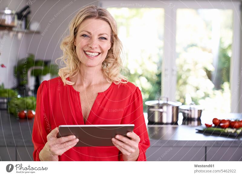 Portrait of smiling woman holding tablet in kitchen digitizer Tablet Computer Tablet PC Tablet Computers iPad Digital Tablet digital tablets smile
