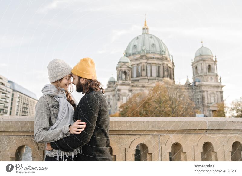 Young couple embracing with Berlin Cathedral in background, Berlin, Germany touristic tourists smile travel traveling embrace Embracement hug hugging seasons