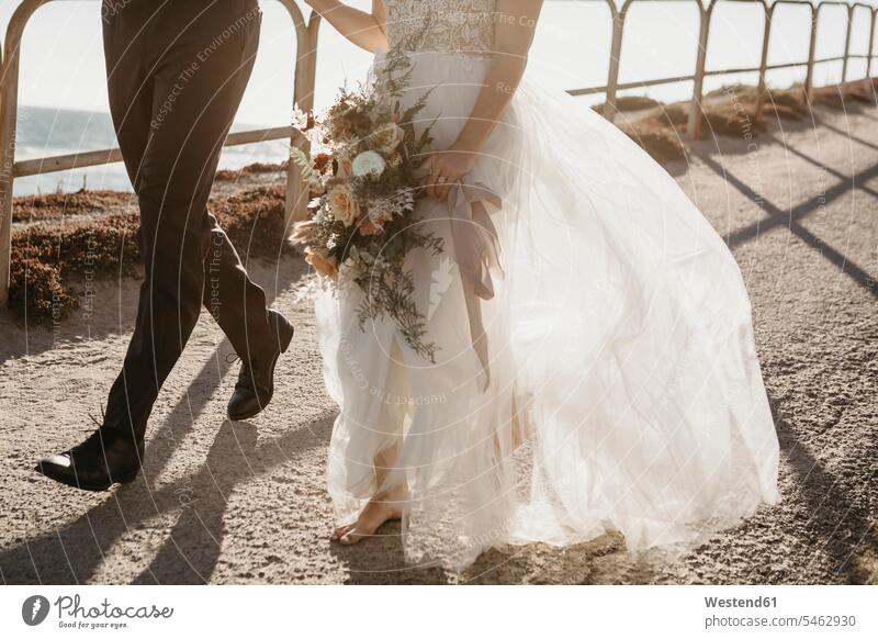 Close-up of bride and groom walking on path at the coast human human being human beings humans person persons caucasian appearance caucasian ethnicity european