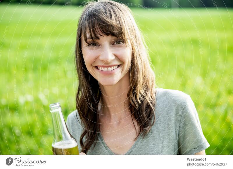 Portrait of smiling brunette woman with a beer bottle outdoors human human being human beings humans person persons caucasian appearance caucasian ethnicity
