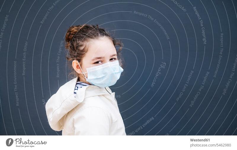 Girl with surgical mask in front of dark blue background White Colors free time leisure time healthy protect protecting safe Safety secure walls location shot
