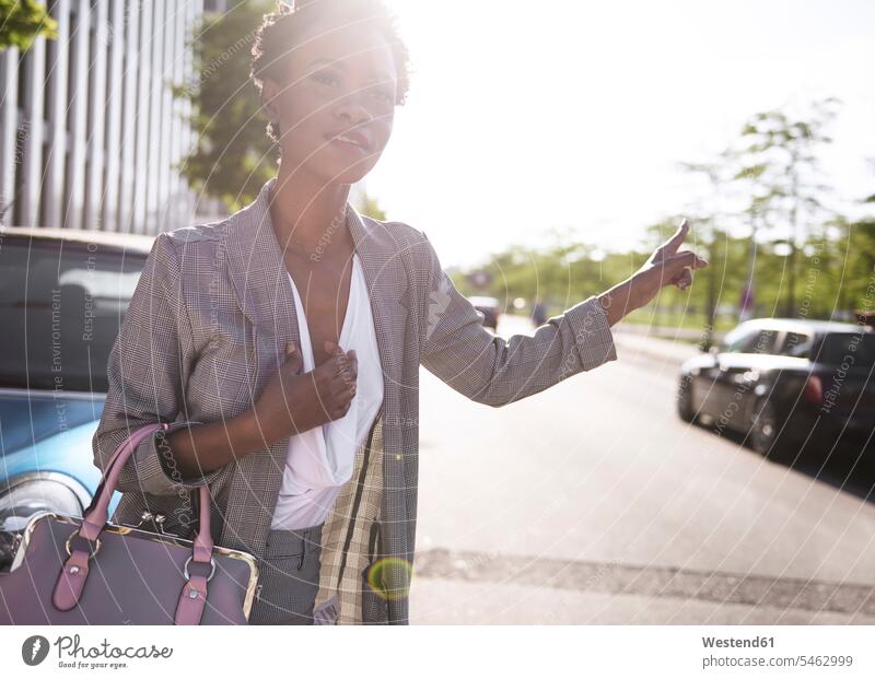 Portrait of businesswoman hailing a taxi portrait portraits businesswomen business woman business women business people businesspeople business world