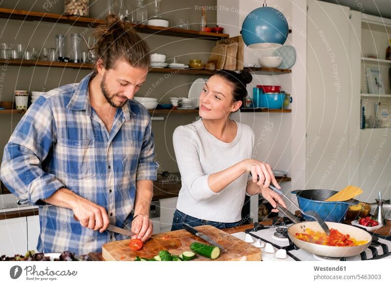 Young couple preparing food together, tasting spaghetti kitchen cooking Food Preparation twosomes partnership couples preparation prepare people persons