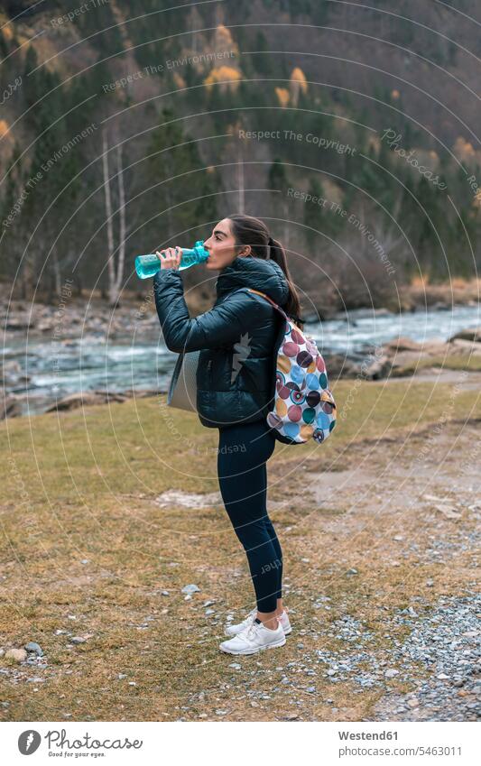 Young woman with backpack drinking water at Ordesa National Park, Huesca, Spain color image colour image outdoors location shots outdoor shot outdoor shots