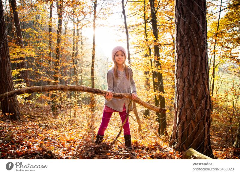 Young girl holding branch in autumn forest Strength strong Force Strengthy Power nature experience standing limb limbs branches females girls Tree Trees