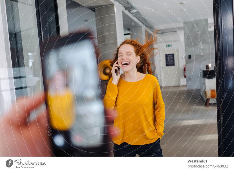 Happy woman with windswept hair on the phone in office human human being human beings humans person persons caucasian appearance caucasian ethnicity european