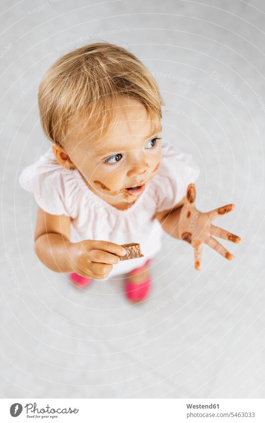 Portrait of little girl eating chocolate cookie blond blond hair blonde hair chocolate biscuit chocolate cookies chocolate biscuits portrait portraits