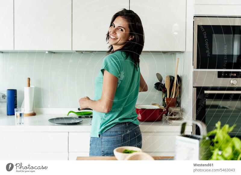 Portrait of smiling woman cooking in kitchen Cooking Pots T- Shirt t-shirts tee-shirt devices Cookers smile delight enjoyment Pleasant pleasure Cheerfulness