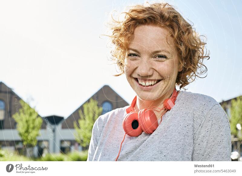 Portrait of happy young woman with headphones in urban surrounding females women headset urbanity happiness Adults grown-ups grownups adult people persons