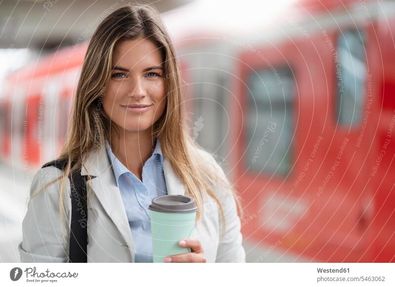 Young businesswoman with coffee to go cup, standing on station human human being human beings humans person persons caucasian appearance caucasian ethnicity