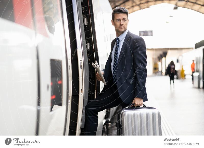 Businessman with suitcase getting in train walking going entering getting into board boarding train station platform Railroad Platform suitcases Business man