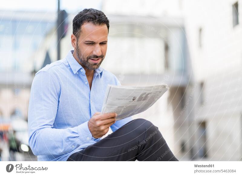 Businessman reading newspaper in the city caucasian caucasian ethnicity caucasian appearance european outdoors outdoor shots location shot location shots