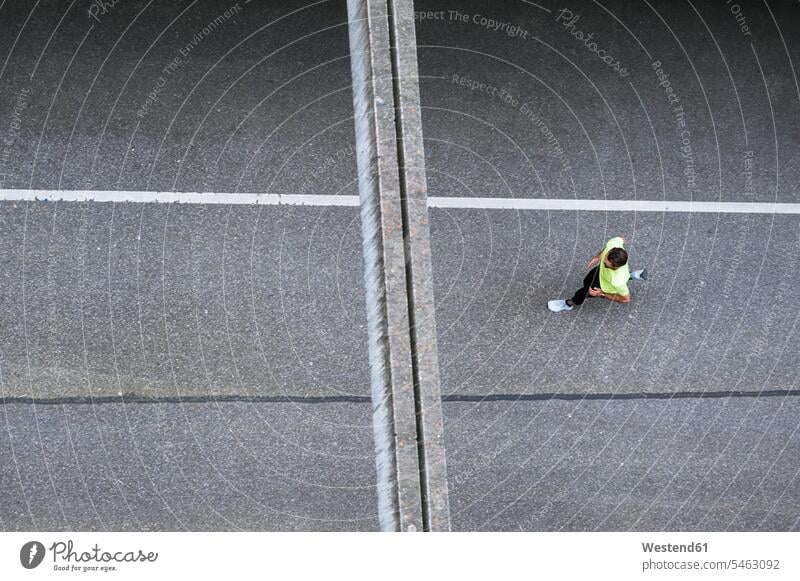 Top view of man running on a street men males road streets roads Adults grown-ups grownups adult people persons human being humans human beings Germany training