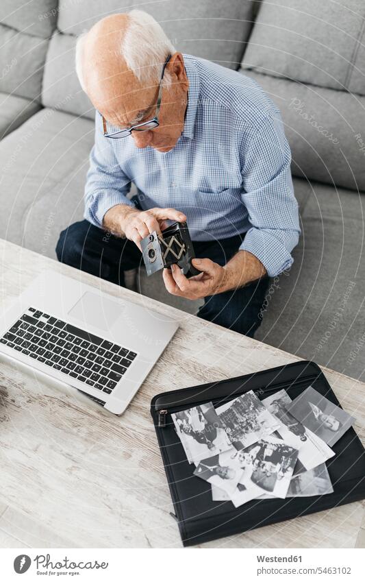 Senior man using laptop and holding his old photo camera, old photos on laptop case wireless Wireless Connection Wireless Technology Wireless Communication