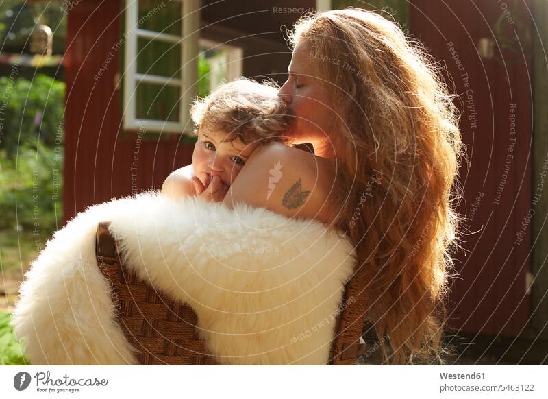 Mother and little daughter cuddling outside holiday home nature natural world daughters mother mommy mothers ma mummy mama snuggle cuddle snuggling