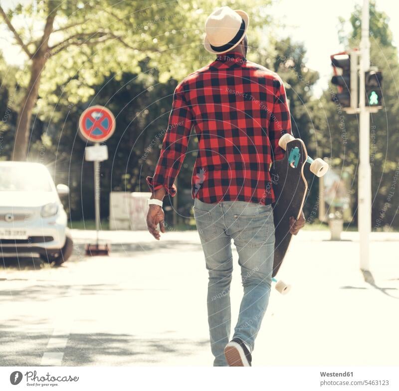 Cool young man with skateboard walking in the city, Skate Board skateboards on the move on the way on the go on the road men males cool attitude composed