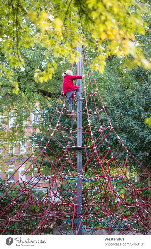 Little girl climbing on jungle gym in autumn fall females girls Jungle gym Jungle gyms child children kid kids people persons human being humans human beings