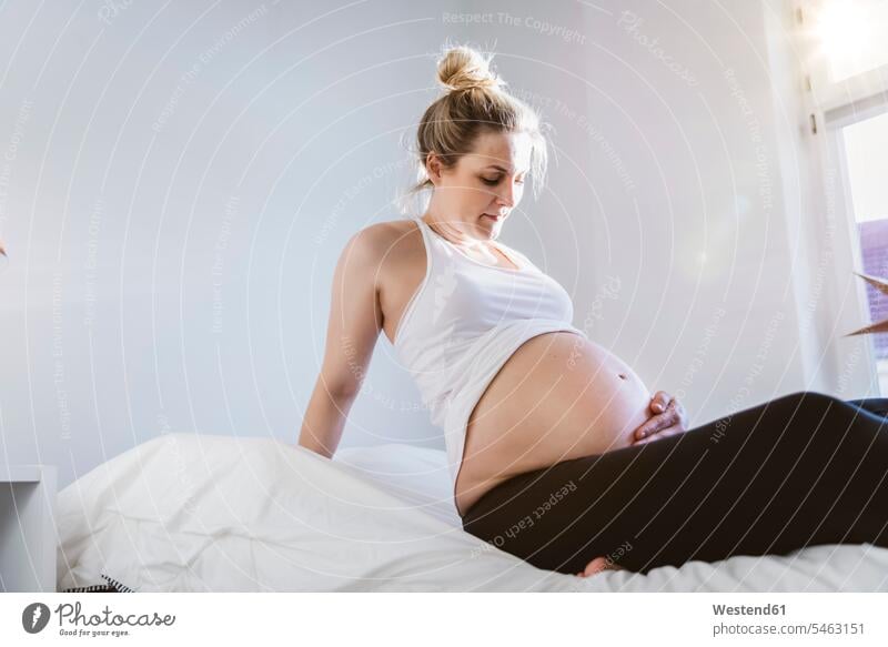 Pregnant woman sitting on bed at home windows Bed - Furniture beds touch Seated relax relaxing relaxation Pregnant Woman free time leisure time Gestation