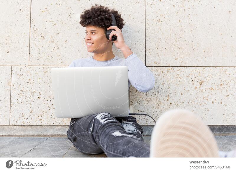 Smiling young man with headphones using laptop in the city human human being human beings humans person persons 1 one person only only one person adult grown-up