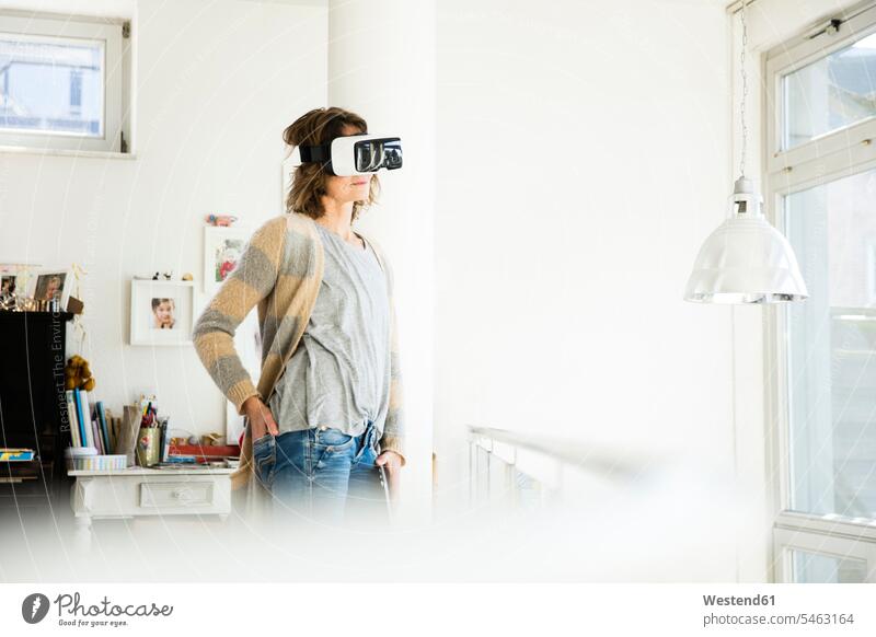 Woman wearing VR glasses at home virtual reality specs Eye Glasses spectacles Eyeglasses woman females women Adults grown-ups grownups adult people persons