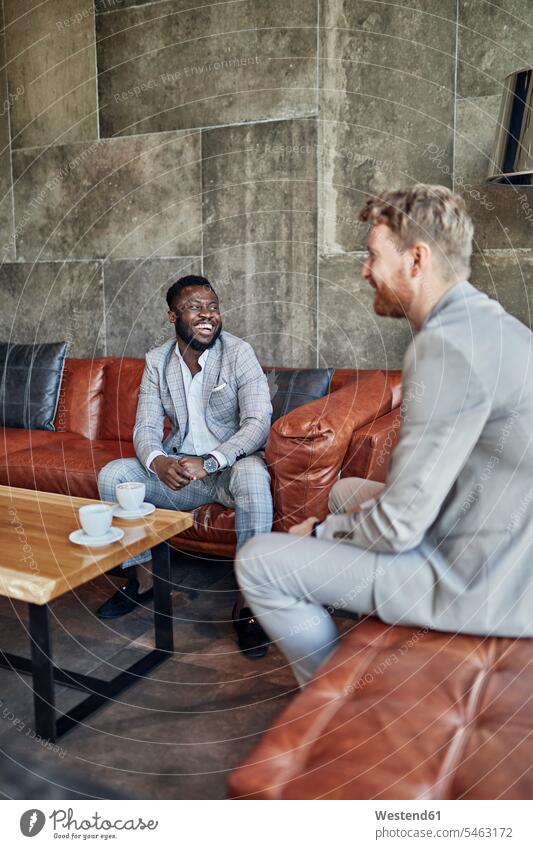 Two happy businessmen having a coffee break in hotel lobby business life business world business person businesspeople associate associates business associate