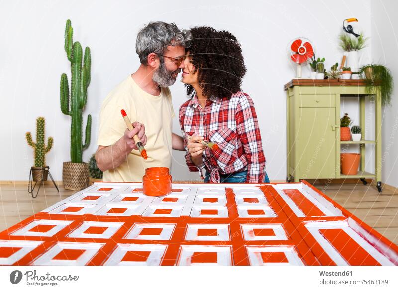 Couple painting furniture with brush at home kiss kisses human human being human beings humans person persons Mixed Race mixed race ethnicity mixed-race Person