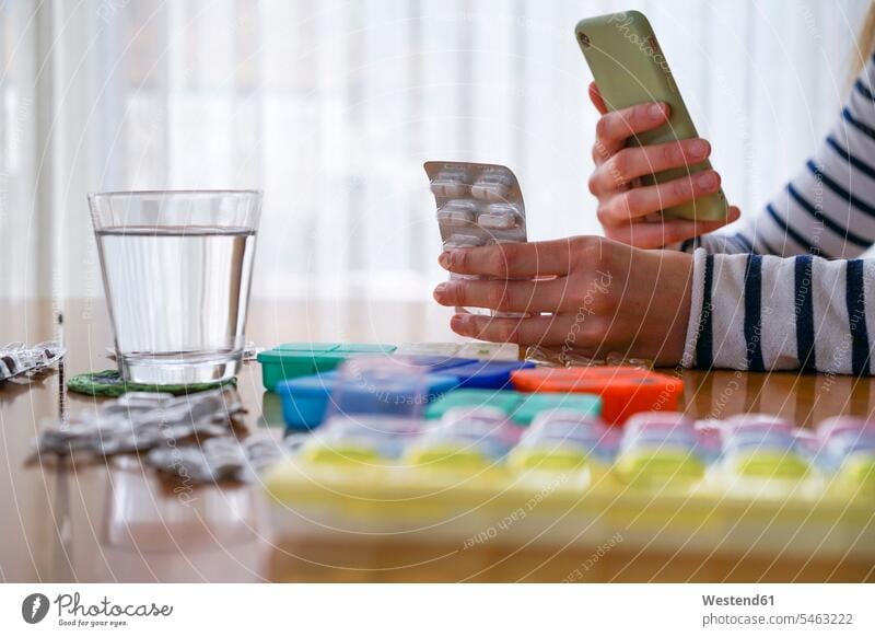 Close-up of woman taking medicine and using smartphone at home human human being human beings humans person persons caucasian appearance caucasian ethnicity