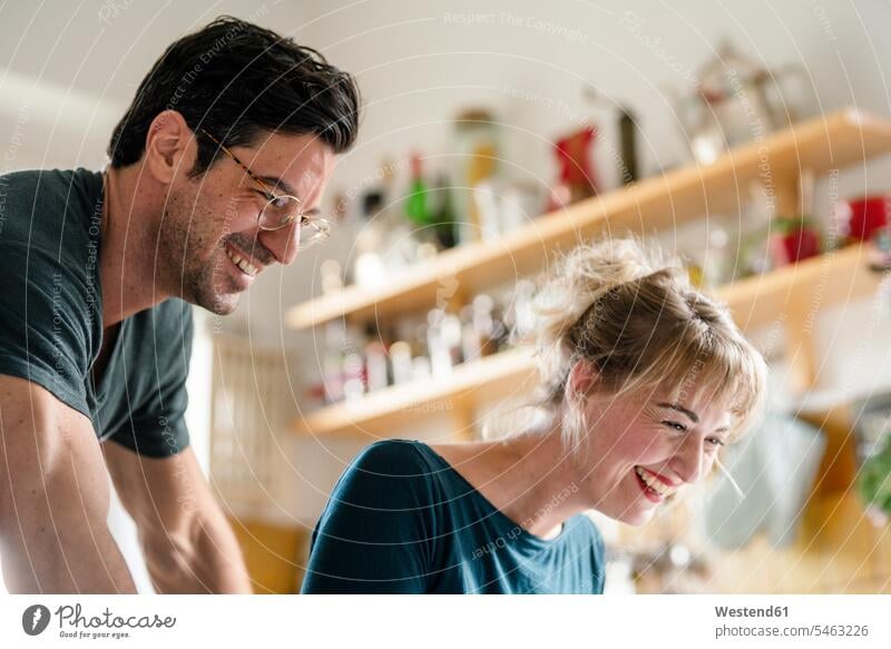 Portrait of happy couple in kitchen at home Eye Glasses Eyeglasses specs spectacles smile delight enjoyment Pleasant pleasure Cheerfulness exhilaration gaiety