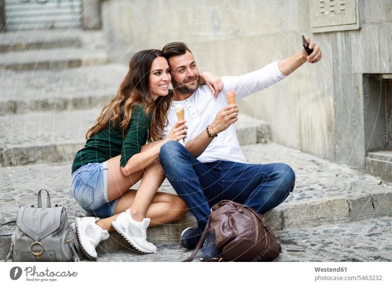 Tourist couple with ice cream cones in the city taking a selfie twosomes partnership couples Ice Cream Cone ice-cream cone Ice Cream Cones ice-cream wafer