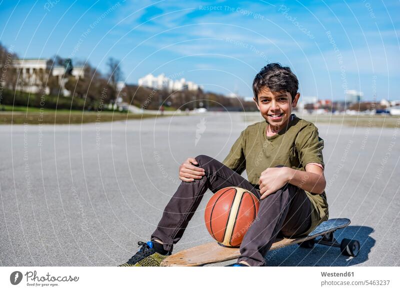 Portrait of smiling boy with longboard and basketball outdoors basketballs boys males smile portrait portraits Longboard Basketball sport sports child children