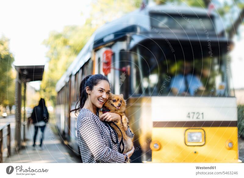 Happy young woman with dog at tram station in the city animals creature creatures domestic animal pet Canine dogs transport railroad railroads Railways