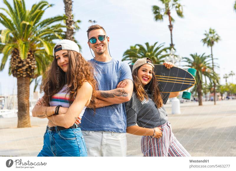 Three happy friends posing with skateboard on a promenade with palms pose Posed promenades Palm Palm Trees Palms portrait portraits happiness Skate Board