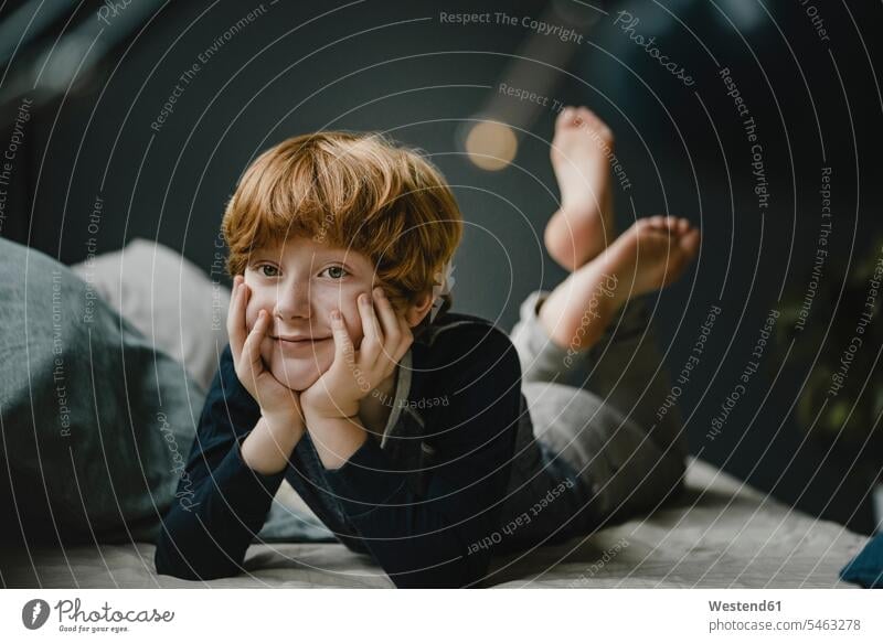 Portrait of smiling redheaded boy lying on couch at home human human being human beings humans person persons caucasian appearance caucasian ethnicity european