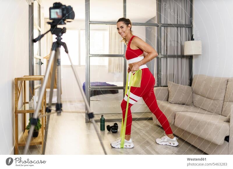 Fitness instructor recording exercise on camera at home color image colour image indoors indoor shot indoor shots interior interior view Interiors day