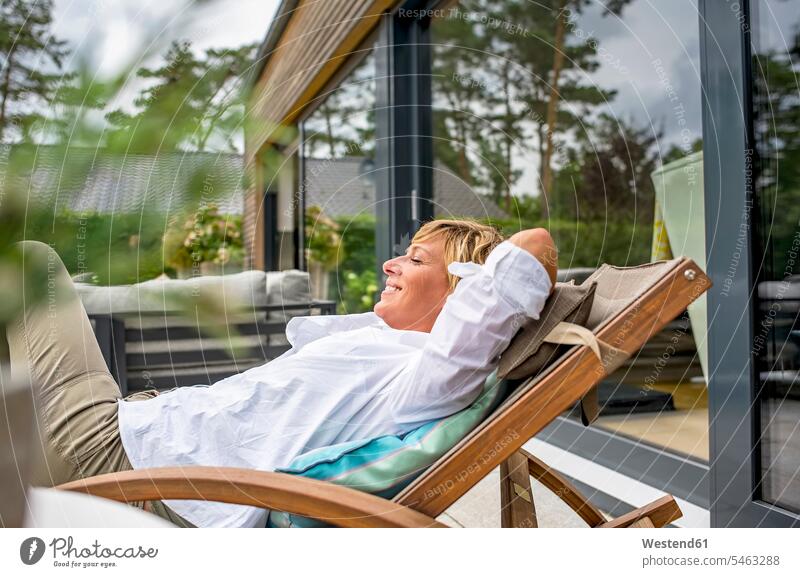 Woman relaxing in deckchair on terrace at home human human being human beings humans person persons celibate celibates singles solitary people solitary person