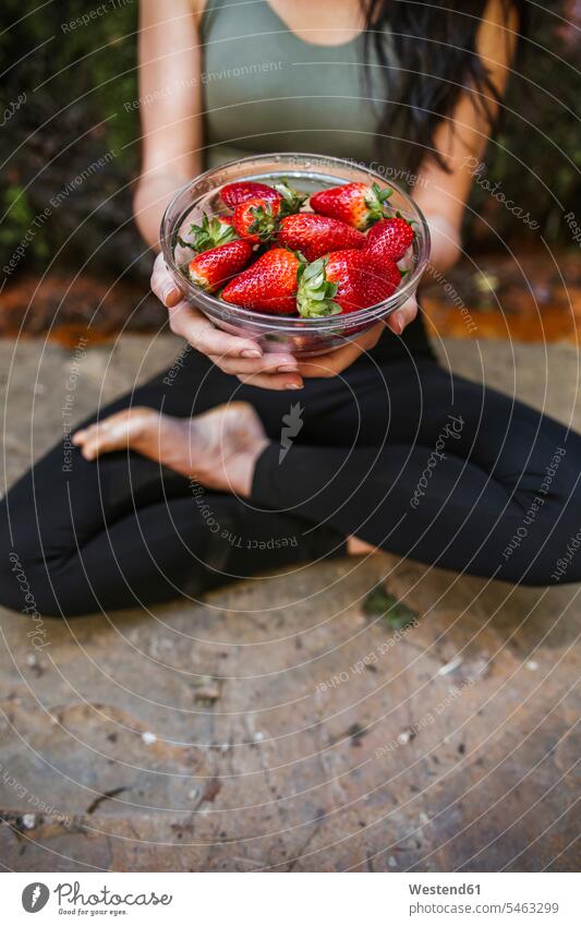 Close-up of woman in yoga pose holding bowl with strawberries Andalusia Andalucia Recreational Pursuit Recreational Activities Recreational Pursuits