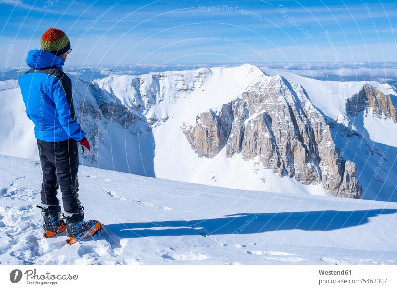Young man looking at view while standing on snowcapped mountain, Umbrian, Italy color image colour image Sibillini Mountains Sibillini Mountain Range