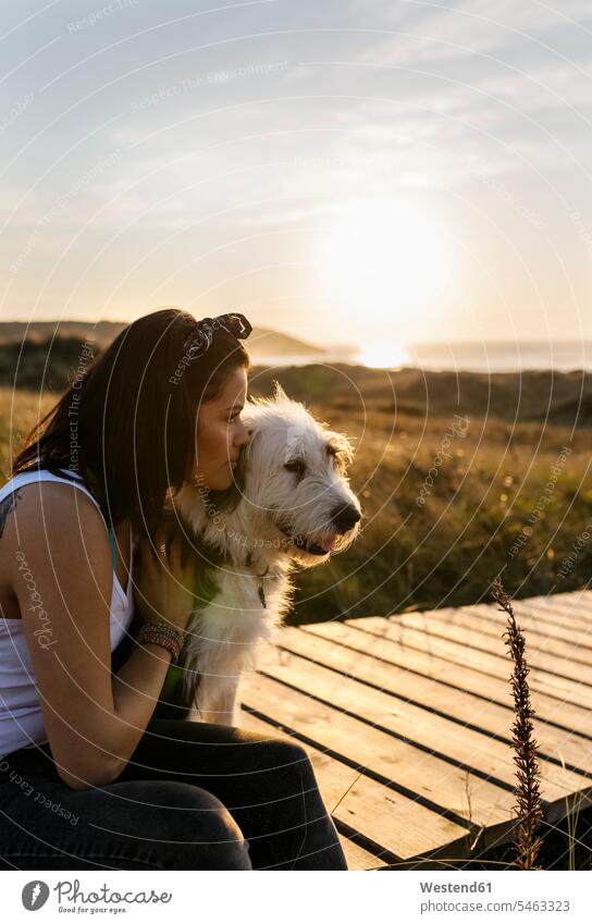 Woman cuddling with dog on boardwalk in dunes animals creature creatures pet Canine dogs relax relaxing Seated sit summer time summertime summery relaxation