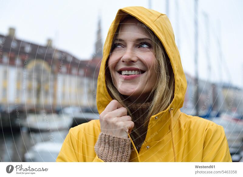 Denmark, Copenhagen, portrait of happy woman at city harbour in rainy weather town cities towns females women happiness portraits outdoors outdoor shots