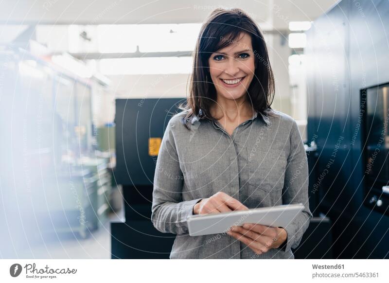Portrait of a smiling businesswoman using a tablet in a factory Occupation Work job jobs profession professional occupation business life business world