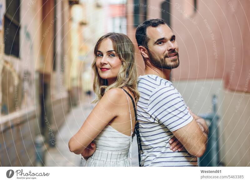 Spain, Andalusia, Malaga, portrait of a tourist couple standing back to back in the city town cities towns portraits tourists twosomes partnership couples