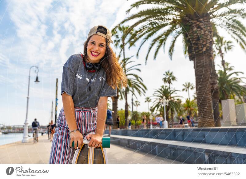Portrait of happy teenage girl with skateboard on a promenade with palms Palm Palm Trees Palms portrait portraits promenades happiness Skate Board skateboards