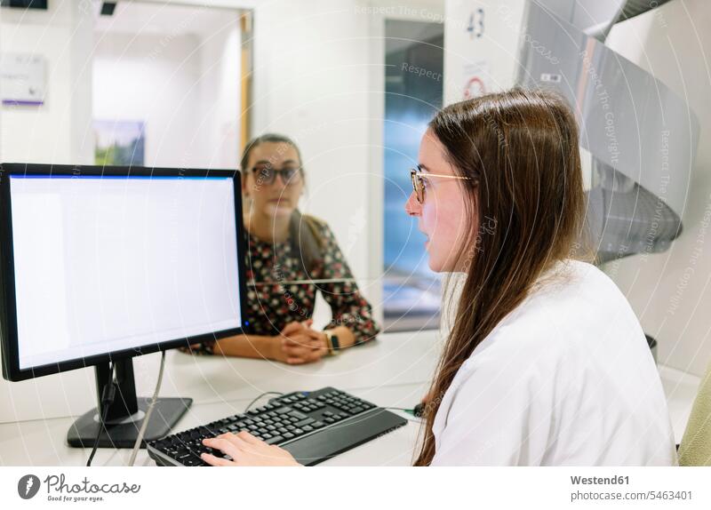 Female pharmacist looking patient's record over computer in hospital color image colour image Spain indoors indoor shot indoor shots interior interior view