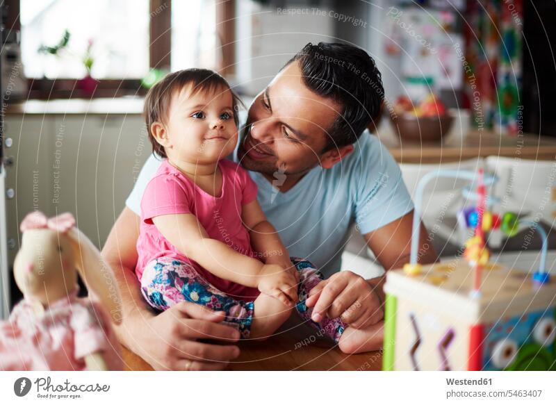 Smiling father with baby girl at home daughter daughters smiling smile pa fathers daddy dads papa infants nurselings babies child children family families