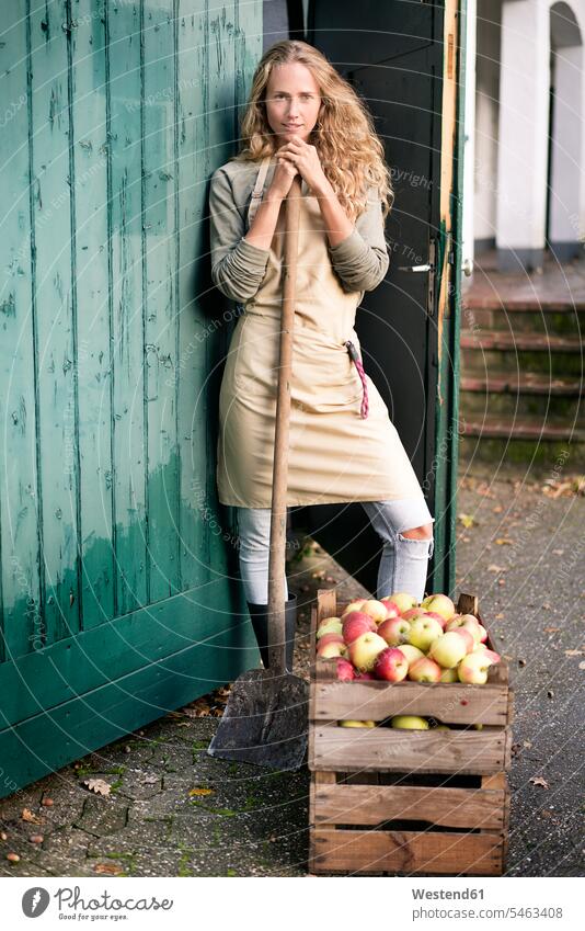 Portrait of confident woman standing at crate with apples crates females women portrait portraits Apple Apples confidence Adults grown-ups grownups adult people