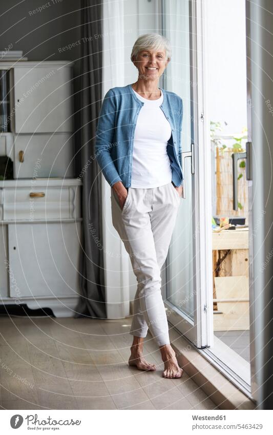 Senior woman standing with hands in pockets at home color image colour image indoors indoor shot indoor shots interior interior view Interiors day daylight shot