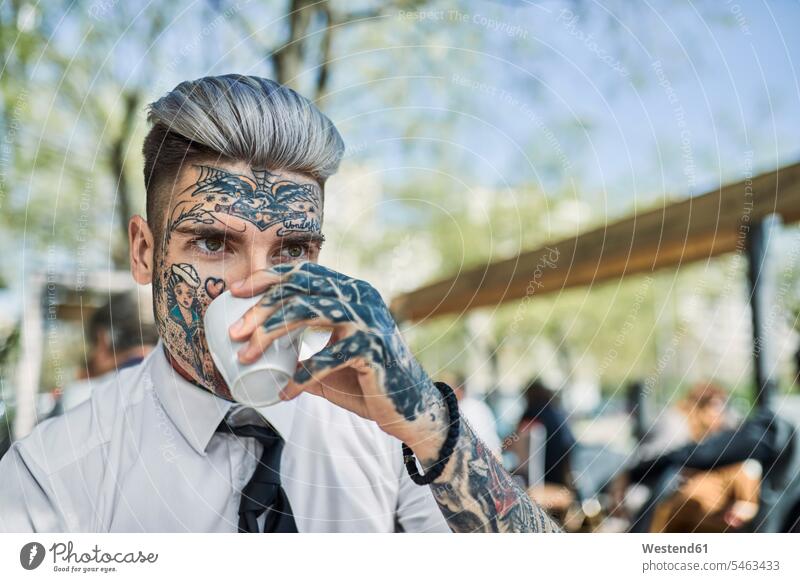 Young businessman with tattooed face, drinking coffee faces Businessman Business man Businessmen Business men Coffee young man young men people persons