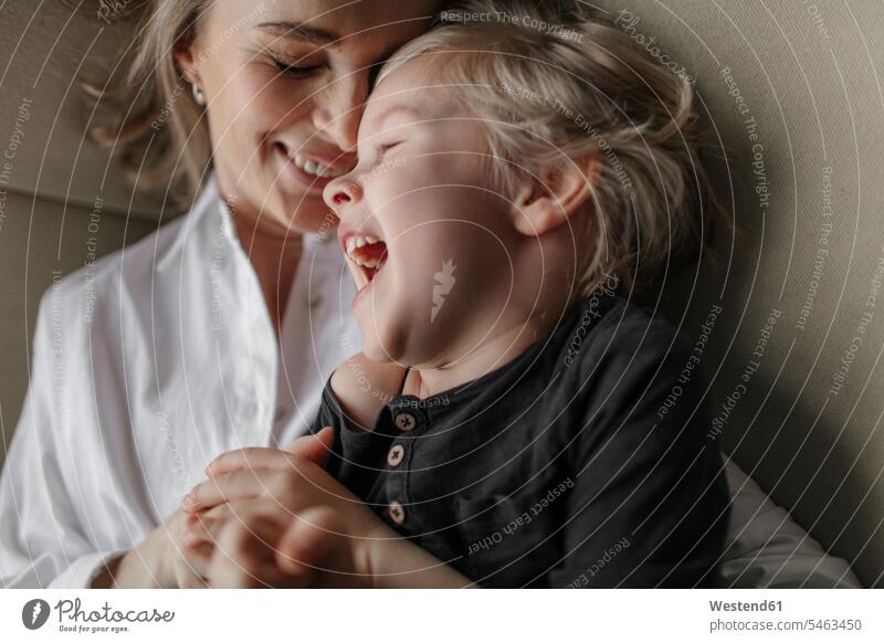 Close-up of blond boy enjoying leisure time with mother at home color image colour image indoors indoor shot indoor shots interior interior view Interiors